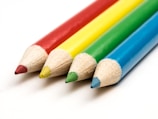 a row of colored pencils sitting next to each other