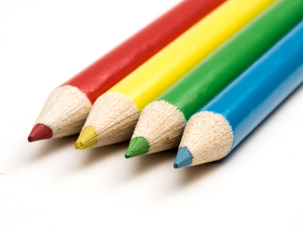 a row of colored pencils sitting next to each other