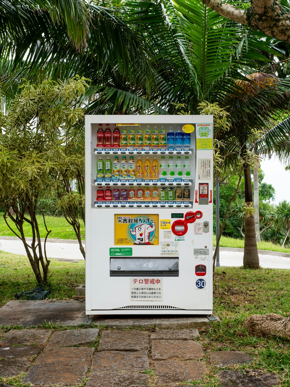 uma máquina de venda automática sentada no meio de um parque