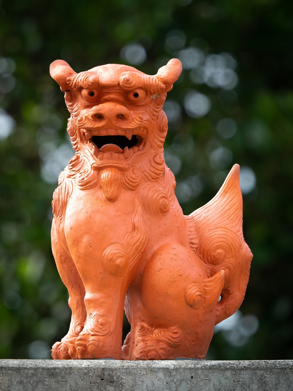 an orange statue of a dog on a ledge