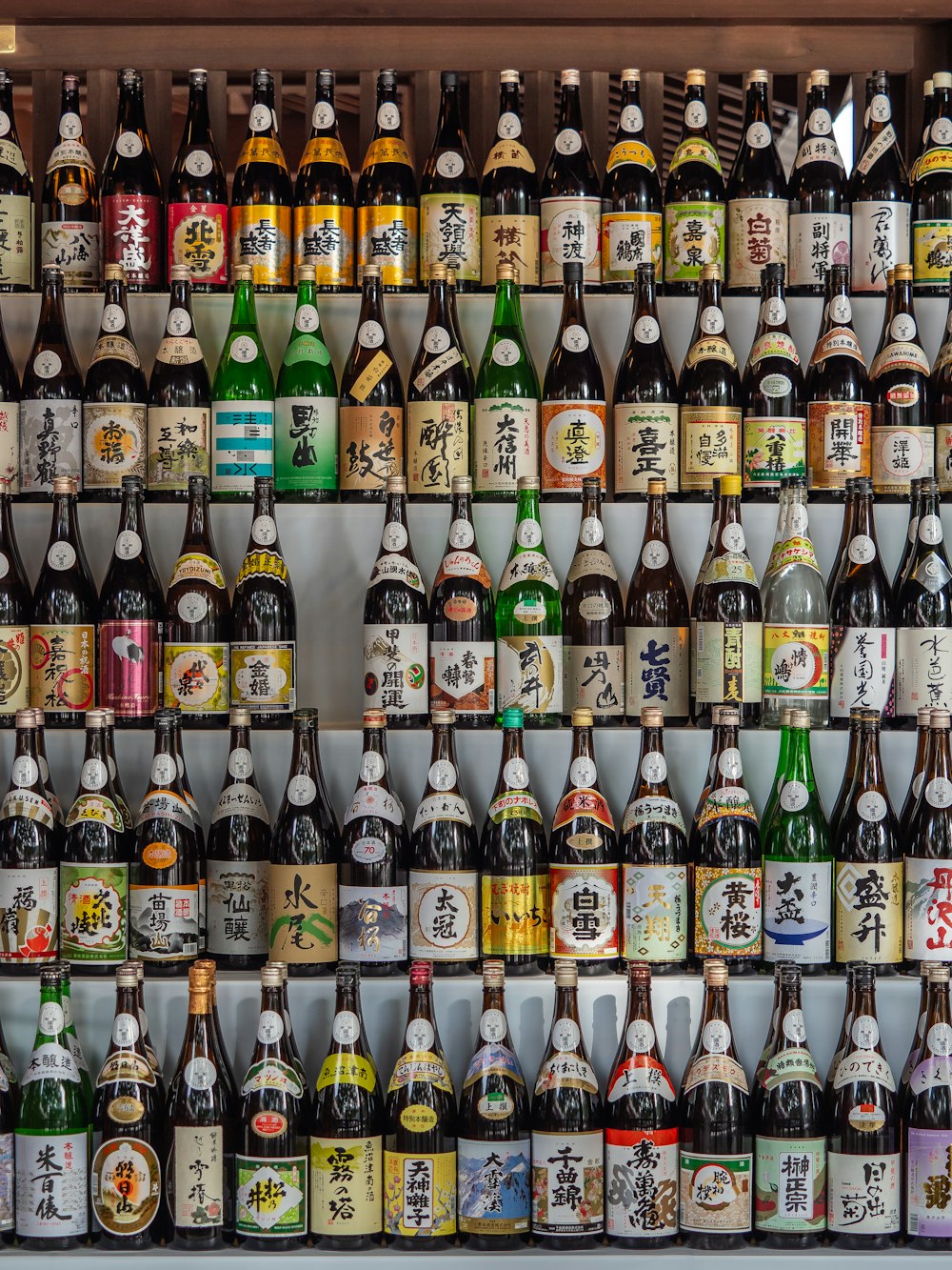 una pared llena de botellas de varios tipos de alcohol