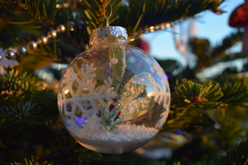 a glass ornament hanging from a christmas tree