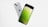 Two smartphones are floating in mid-air against a plain white background. The phones are angled to showcase both their front and back sides. The front side displays a screen with a gradient of green shades, while the back side has a silver finish and a recognizable logo.