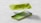 A lime green smartphone is split into two parts, with the back and front panels separated. The back panel features a dual camera system, while the front shows a screen displaying a green abstract pattern. The phone is set against a simple gray background, emphasizing its sleek design.