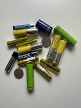 Various types of batteries including dry, lithium, and EV bike batteries displayed on a table.