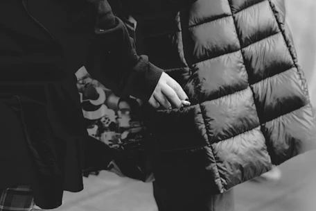 Close-up shot of a high-quality, structured jacket with sharp lines in grayscale.