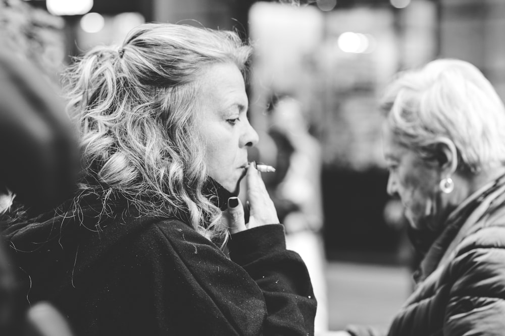 a black and white photo of a woman talking on a cell phone