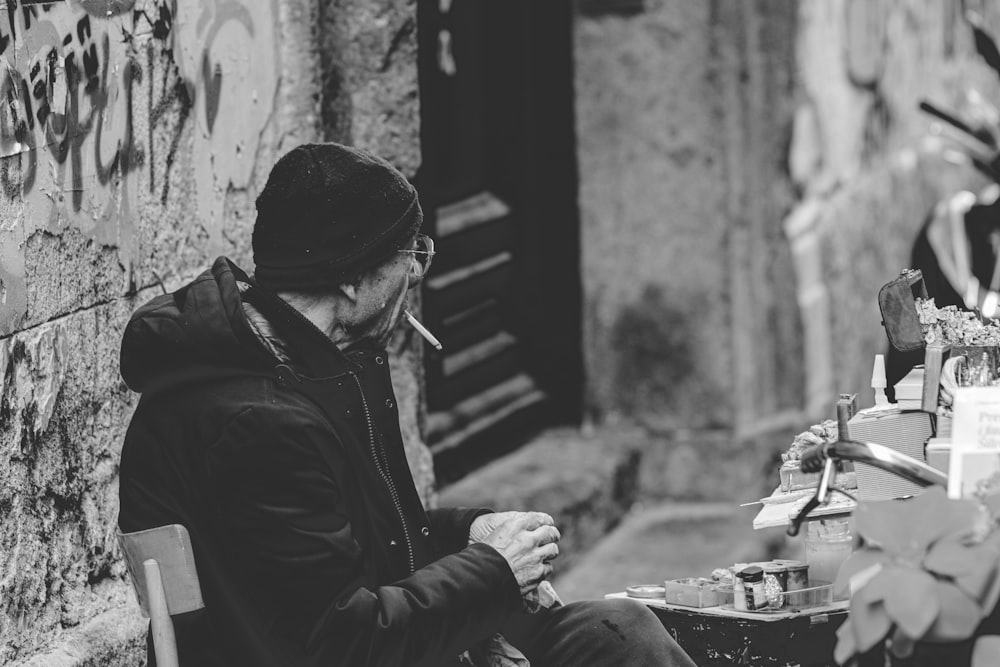 a man sitting on a bench smoking a cigarette