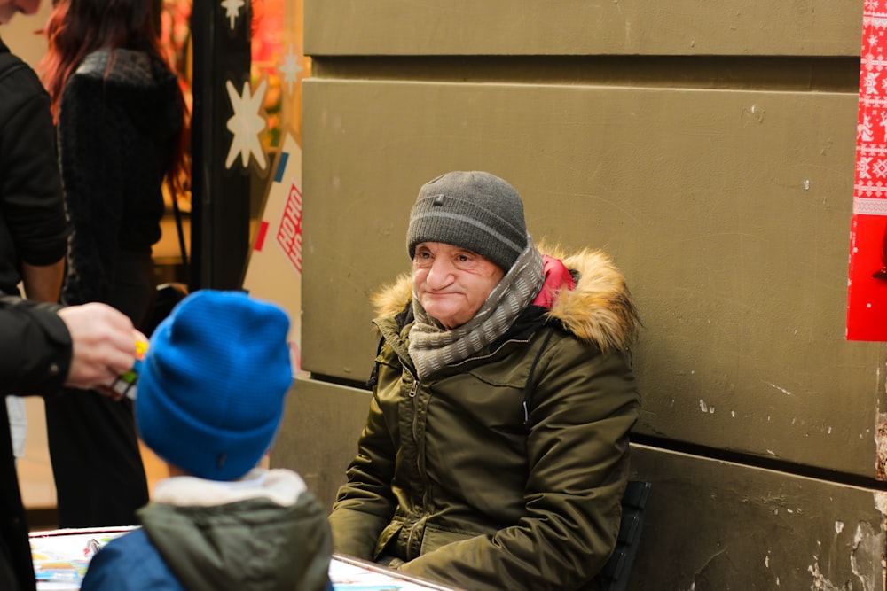 a man sitting on a bench next to a little boy