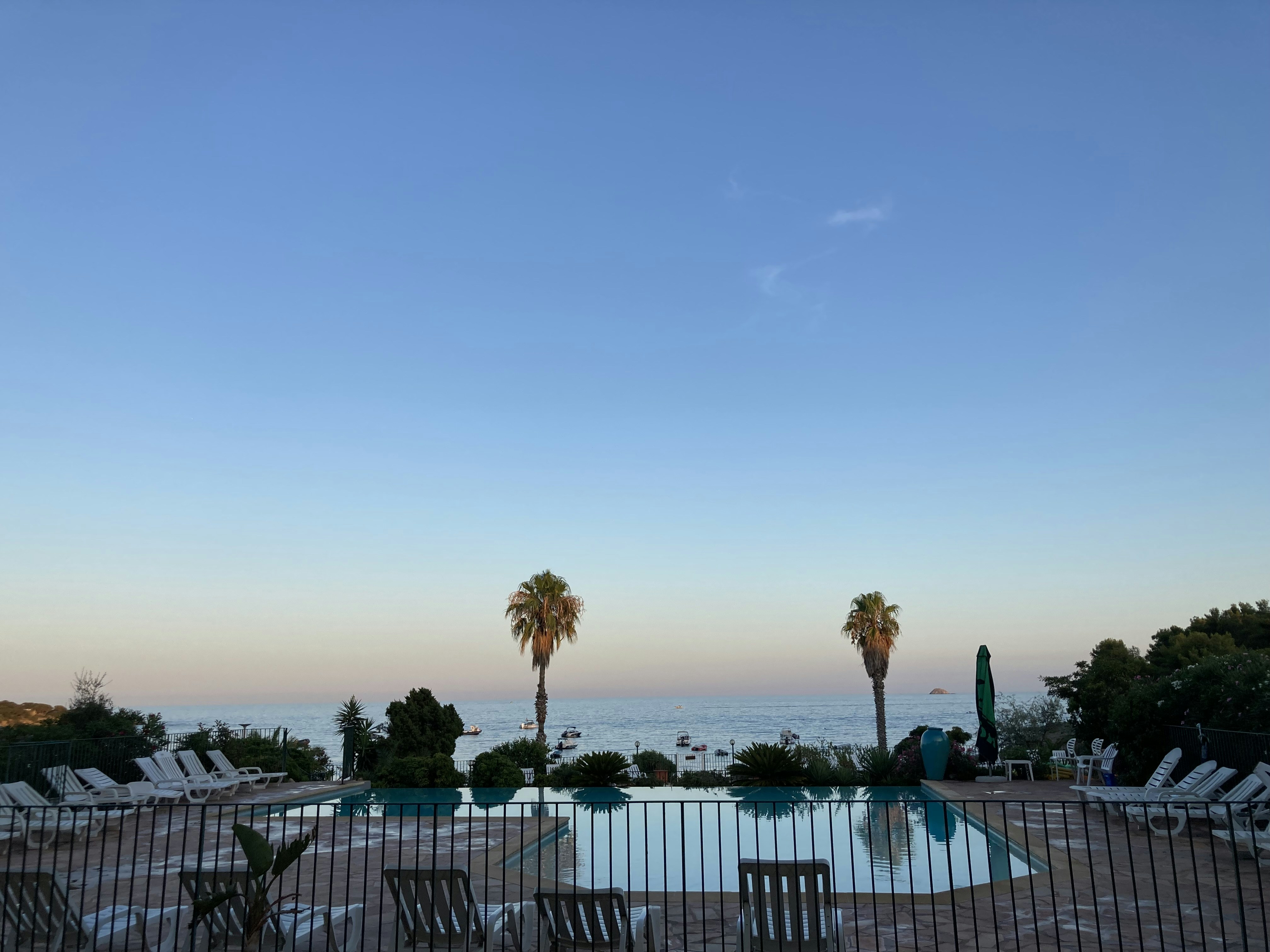 Beach bar terrace with parasols at dusk overlooking the calm Mediterranean sea