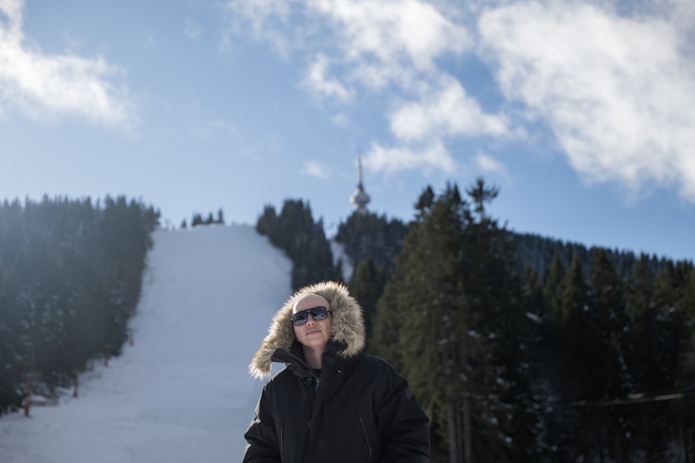 uma mulher em pé em uma pista de esqui coberta de neve