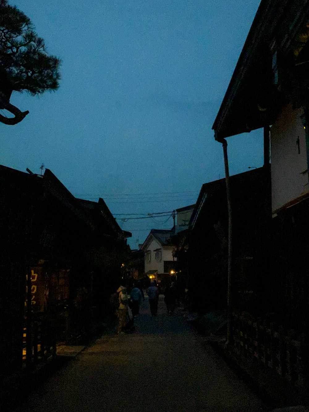 a group of people walking down a street at night