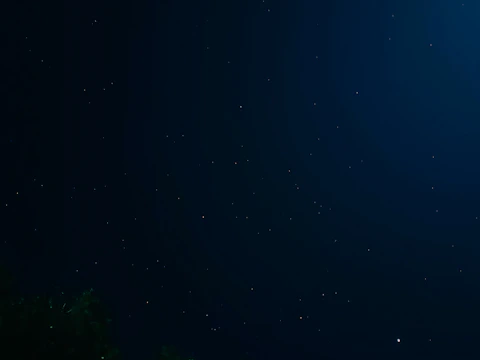 A tranquil blue night sky with constellations forming tarot symbols