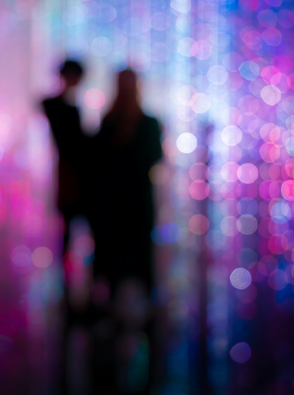 a blurry photo of two people standing in front of a wall