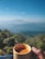 Close-up of a joyful woman holding a cup of herbal tea with Himalayan mountains in the background.