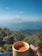 A smiling family enjoying tea on the guest house balcony with mountain views.
