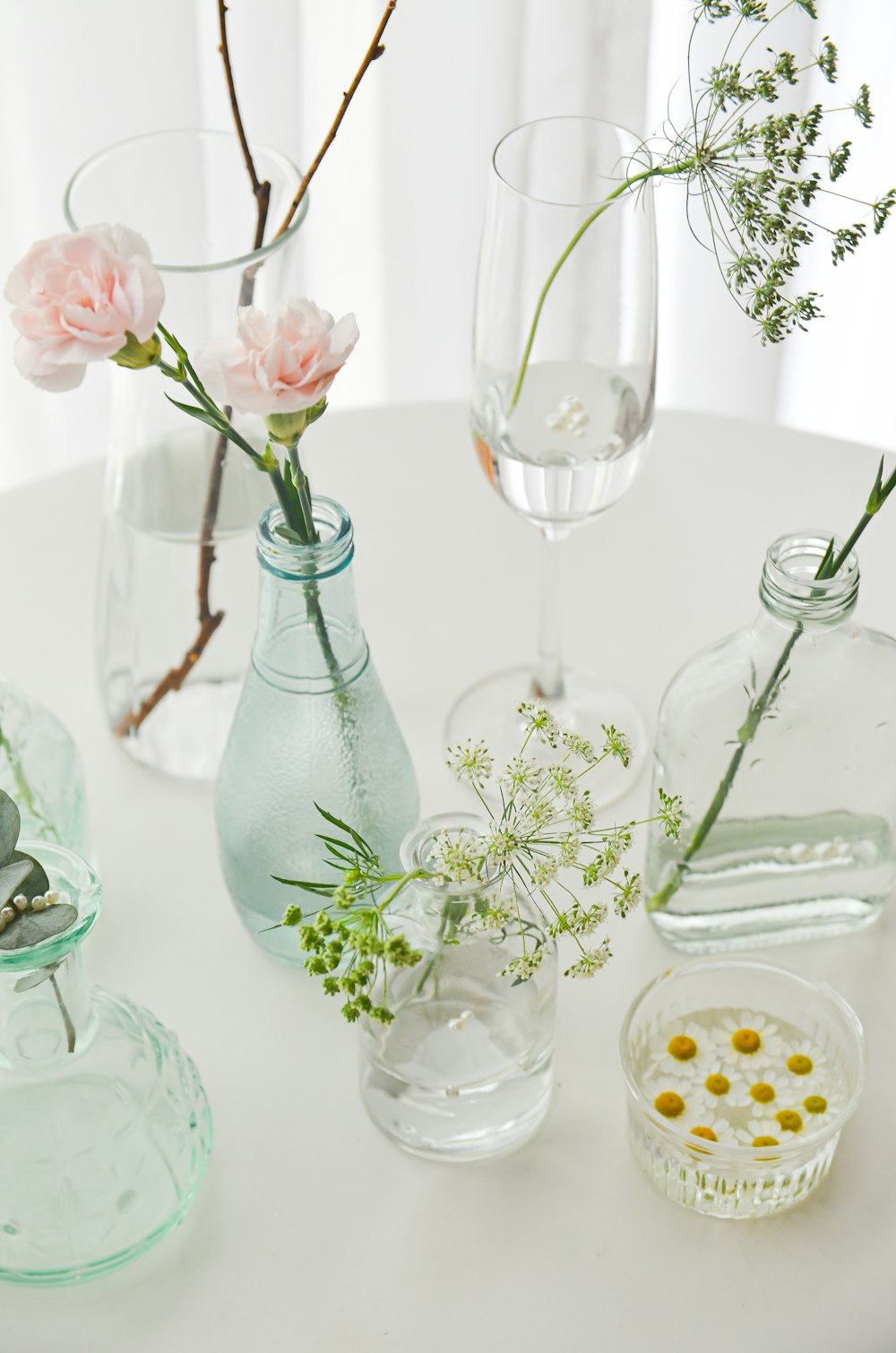 uma mesa branca coberta com vasos cheios de flores