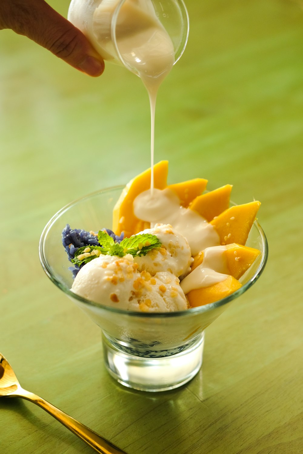 a glass bowl filled with ice cream and fruit