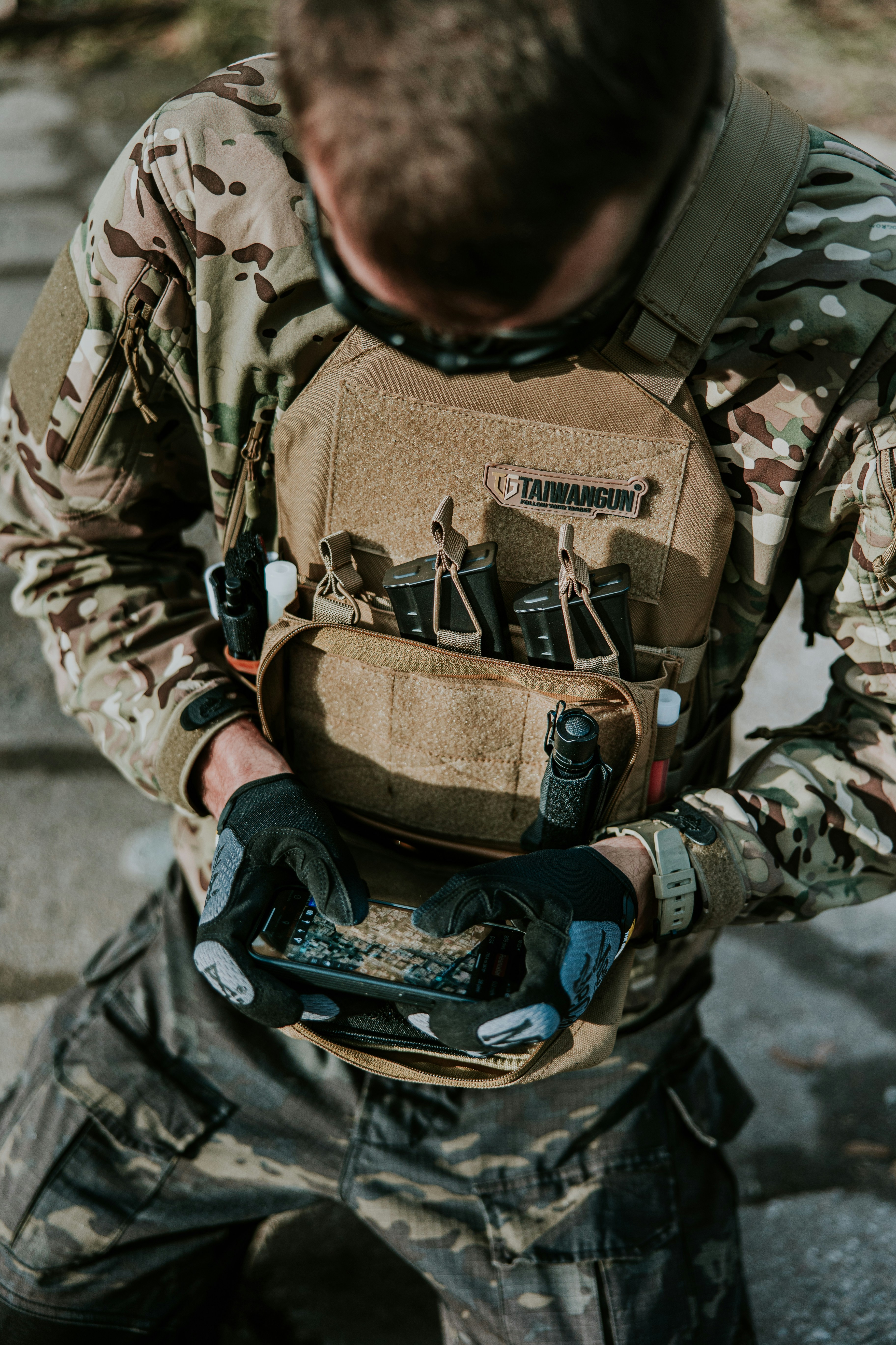 a man in camouflage holding a tool bag