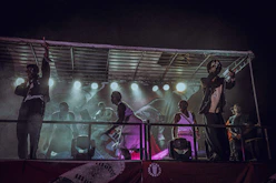A lively group of young performers rehearsing on stage with colorful lights.