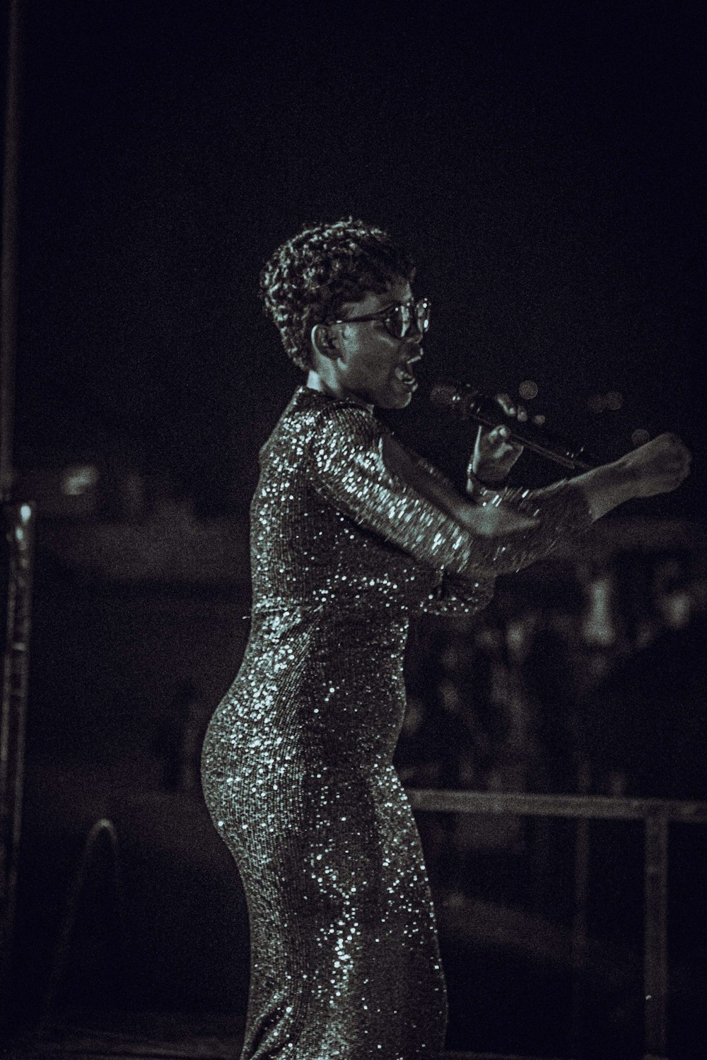 a woman in a sequin dress holding a microphone