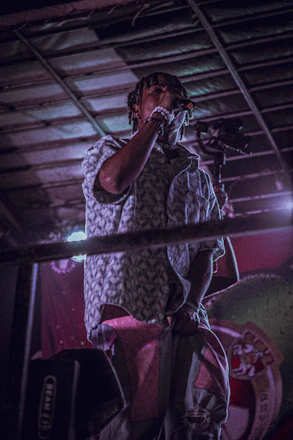 A dynamic photo of Diego Cardenas confidently speaking on stage with vibrant lighting.