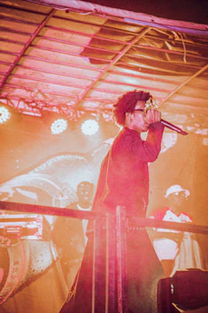 A vibrant studio scene with a microphone, mixing board, and a performer practicing on stage