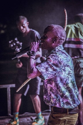 Close-up of a freestyle rapper performing passionately on a dimly lit stage.