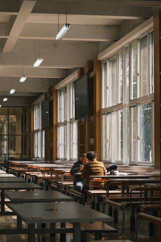 Hospital staff and visitors enjoying meals in a calm, softly lit dining area.