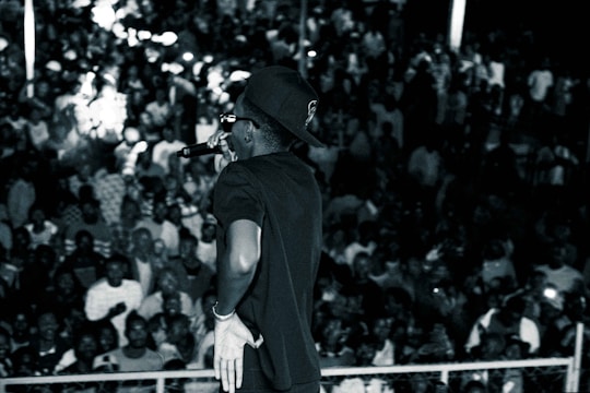 A performer dressed as a celebrity look-alike entertaining a crowd at a lively party.