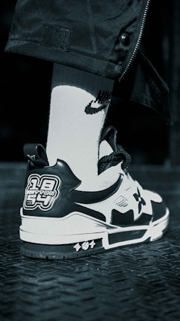 A sleek black-and-white sock prototype displayed on a modern workbench with design sketches.