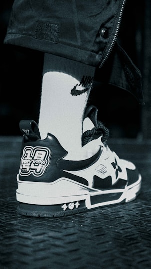 A sleek black-and-white sock prototype displayed on a modern workbench with design sketches.