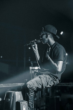 a man sitting on top of a stage holding a microphone
