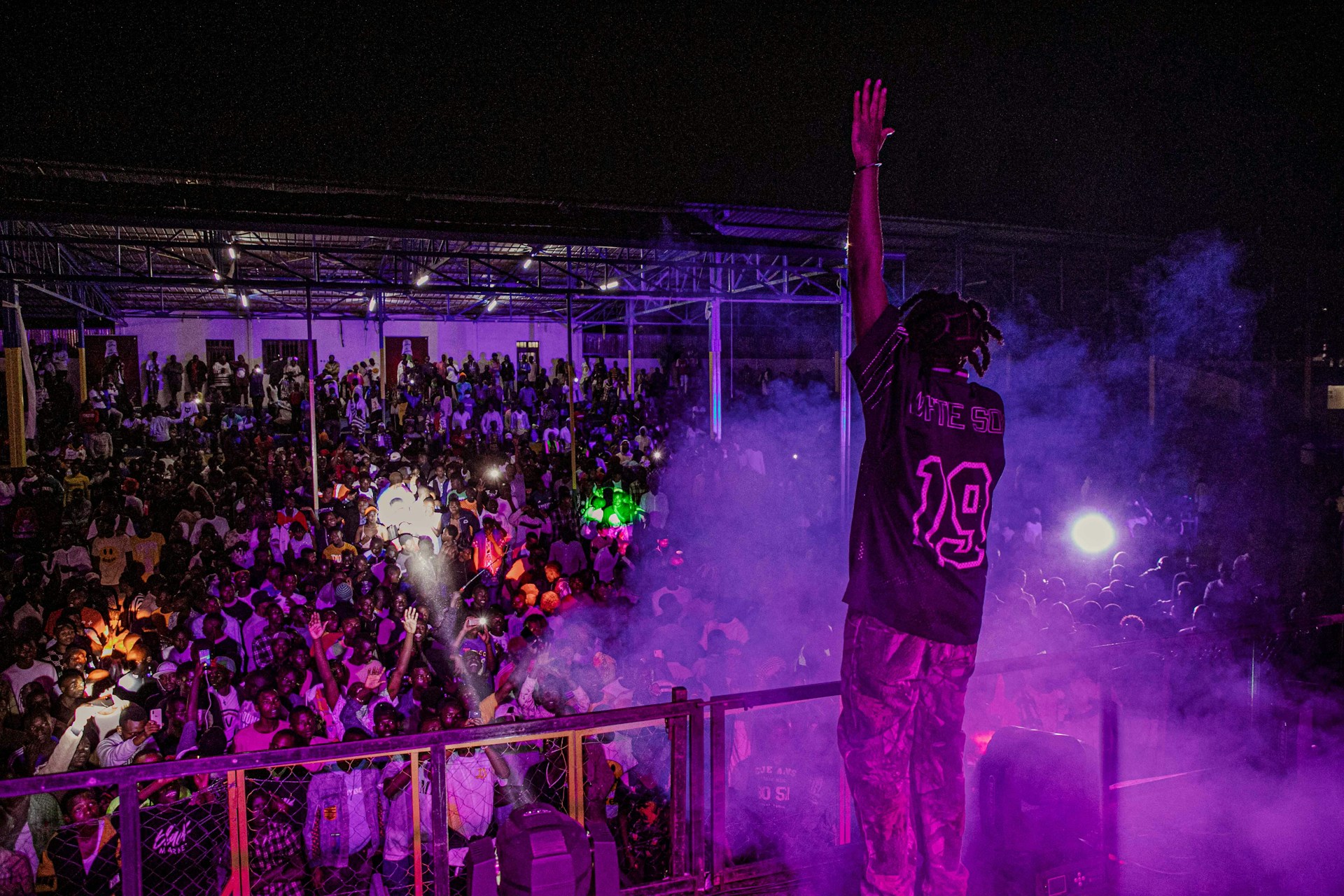 Hassan Badshah performing passionately on stage with vibrant lights and an engaged crowd.