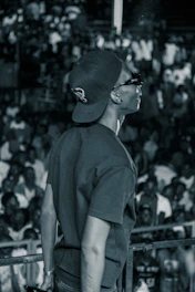 A candid shot of a confident person speaking passionately on stage with a warm audience.