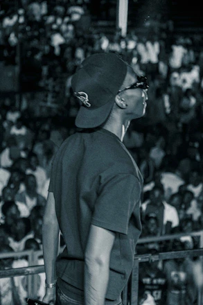 A candid shot of a confident person speaking passionately on stage with a warm audience.