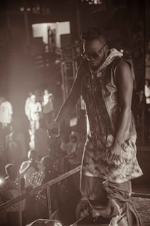 Mike Andrew performing on stage in a sharp suit, capturing Robbie Williams' iconic style.