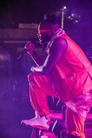 Daniel on stage at a local event, orange lighting highlighting his presence.