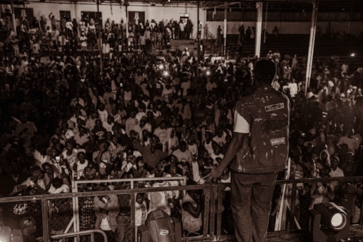 A vibrant, energetic photo of Danielle Joleigh Bennett speaking passionately on stage with a dynamic audience in the background.