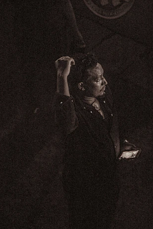 A solitary person looking at a phone with an ignored message, surrounded by a dark emotional atmosphere with rain and cold light in green and black tones.