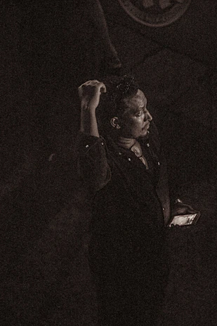 A solitary person looking at a phone with a message ignored, surrounded by a dark emotional atmosphere with cold rain and green-black tones, evoking strong psychological feelings.