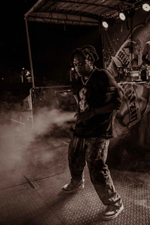 Wide shot of Jaiden performing live on stage with a subtle smoky atmosphere and elegant minimal backdrop