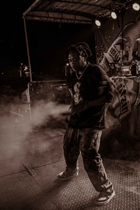 Portrait of Jairaj Kalsy performing passionately under warm stage lighting with a deep charcoal and gold backdrop.
