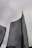 Tall, modern skyscrapers with curved facades rise against a cloudy sky, one bearing the UniCredit logo near its top.