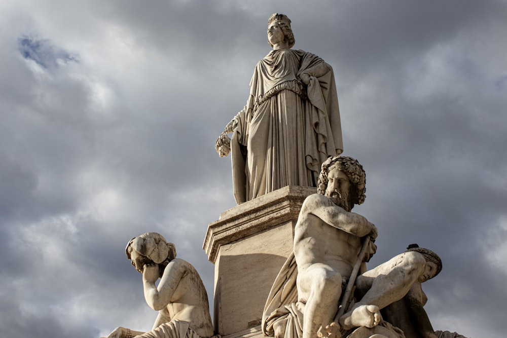 Una estatua en lo alto de un edificio con nubes en el fondo