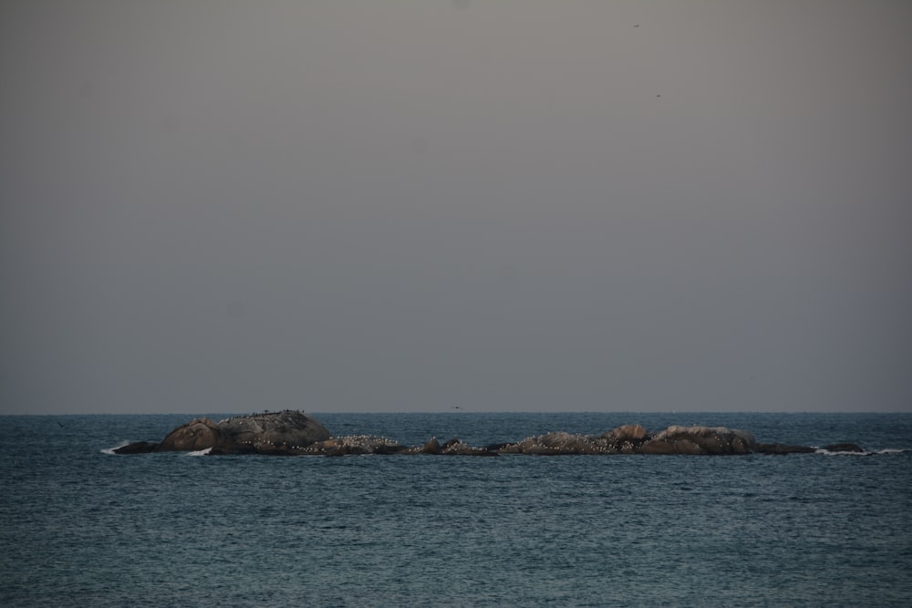 a large rock in the middle of the ocean