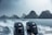 Twin Suzuki 200 outboard motors on the back of a boat with water spraying and a backdrop of rocky islands under an overcast sky. The scene is rainy, with visible water droplets.
