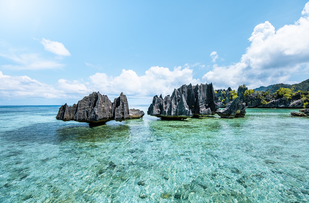 a group of rocks sitting on top of a body of water