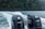 Two dark-colored outboard motors with the brand logo and number 200 are seen at the back of a boat traveling on water, surrounded by lush green forests in the background under rainy weather.