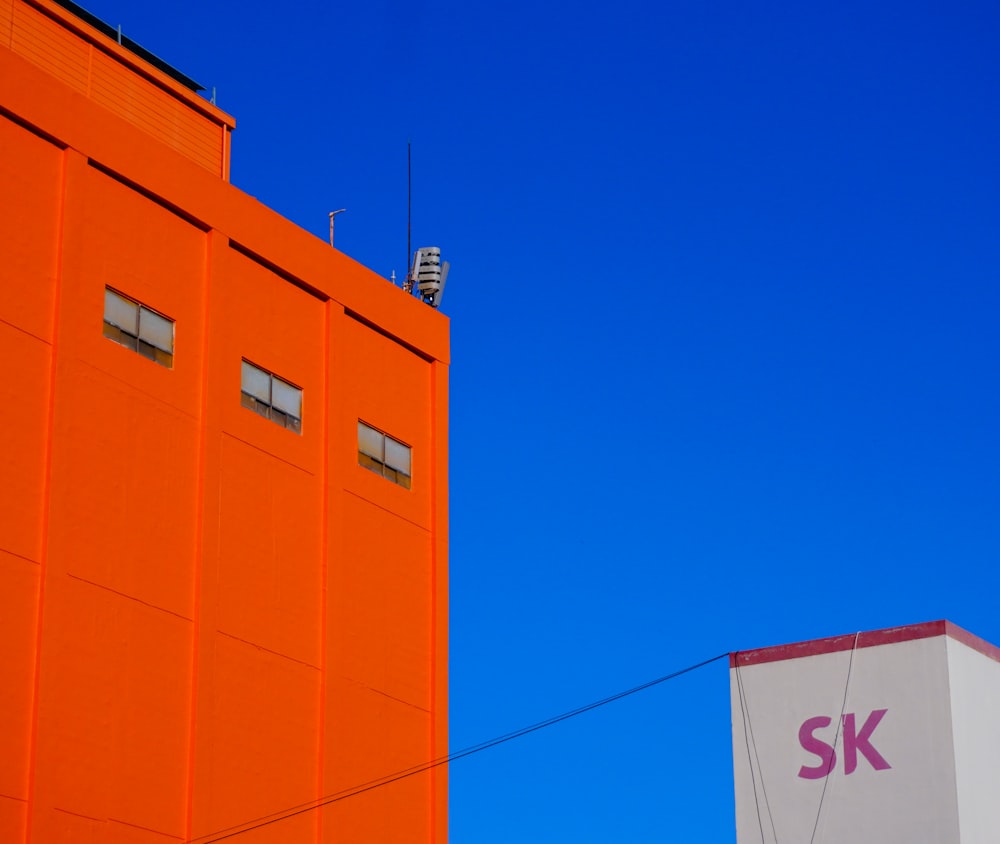 a tall orange building next to a tall white building
